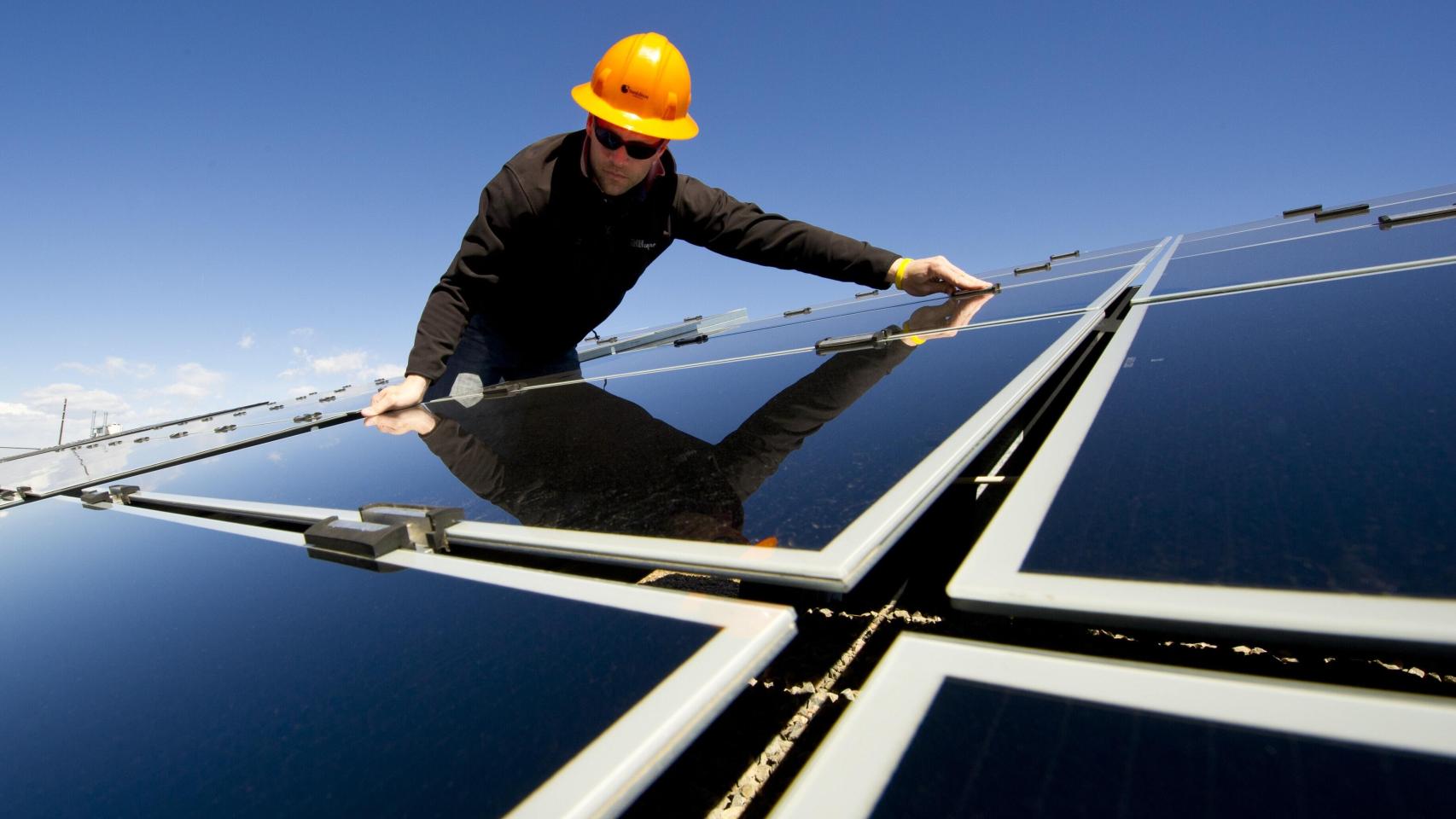 Un operario instalando paneles solares.