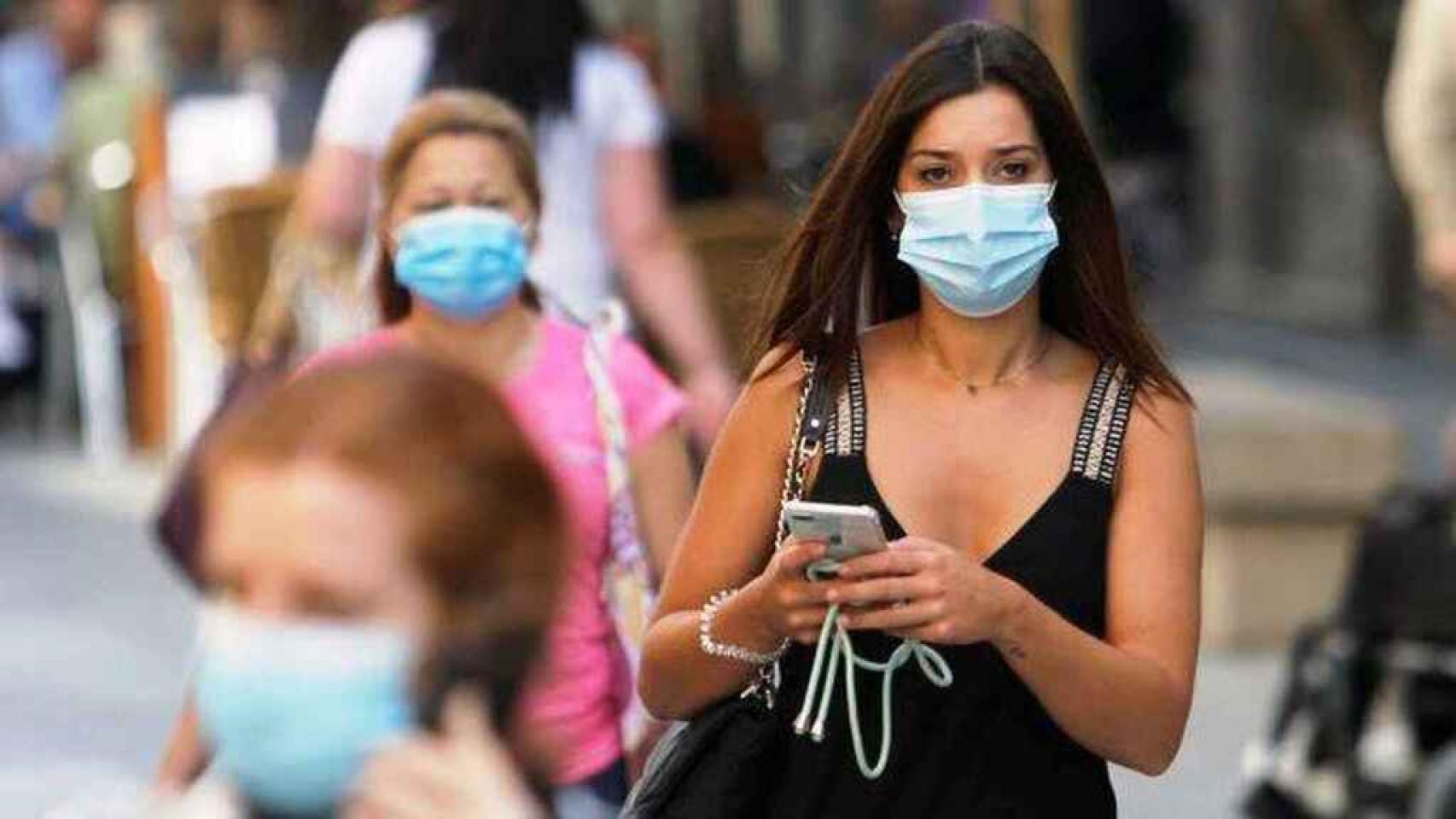 Varias personas con mascarilla.