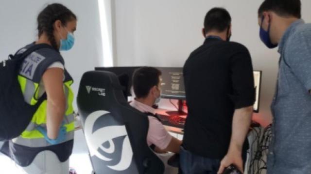 Los agentes, registrando el ordenador del detenido.