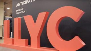 Un rótulo de LLYC en un evento sobre comunicación corporativa.