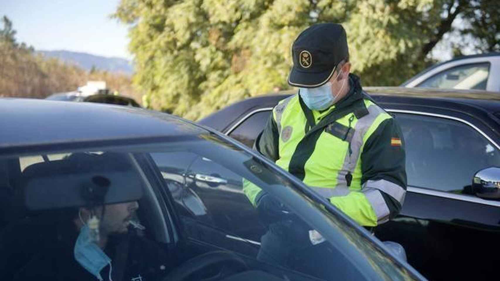 Un agente de la Guardia Civil solicitando a un conductor su documentación.