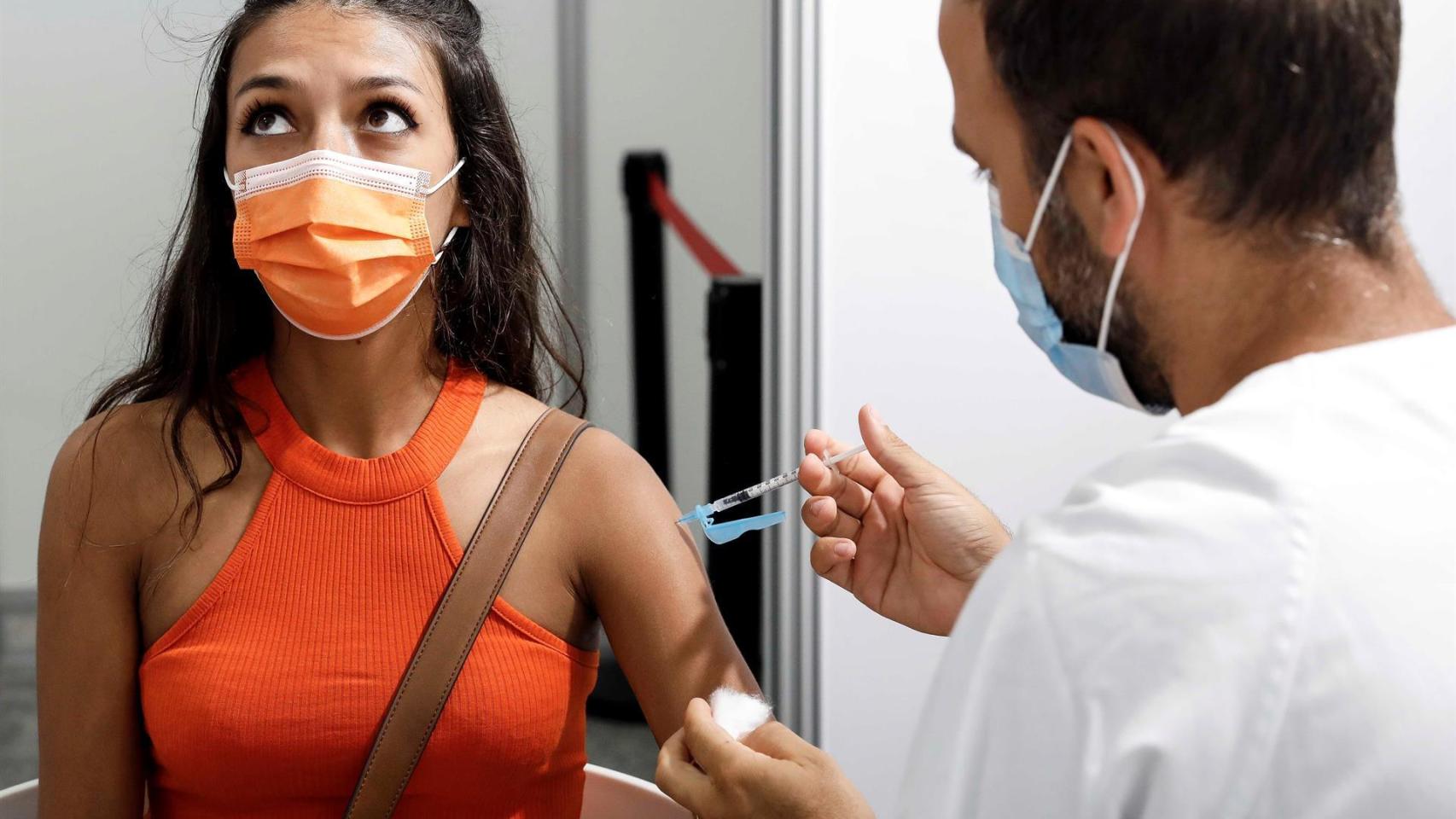 Un sanitario pone una vacuna contra la Covid-19 a una paciente.