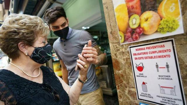 Una clienta muestra su pasaporte Covid para entrar a un establecimiento.