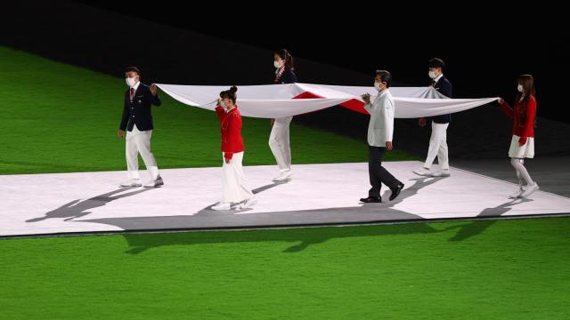 La bandera de Japón portada por los voluntarios de Tokio 2020.
