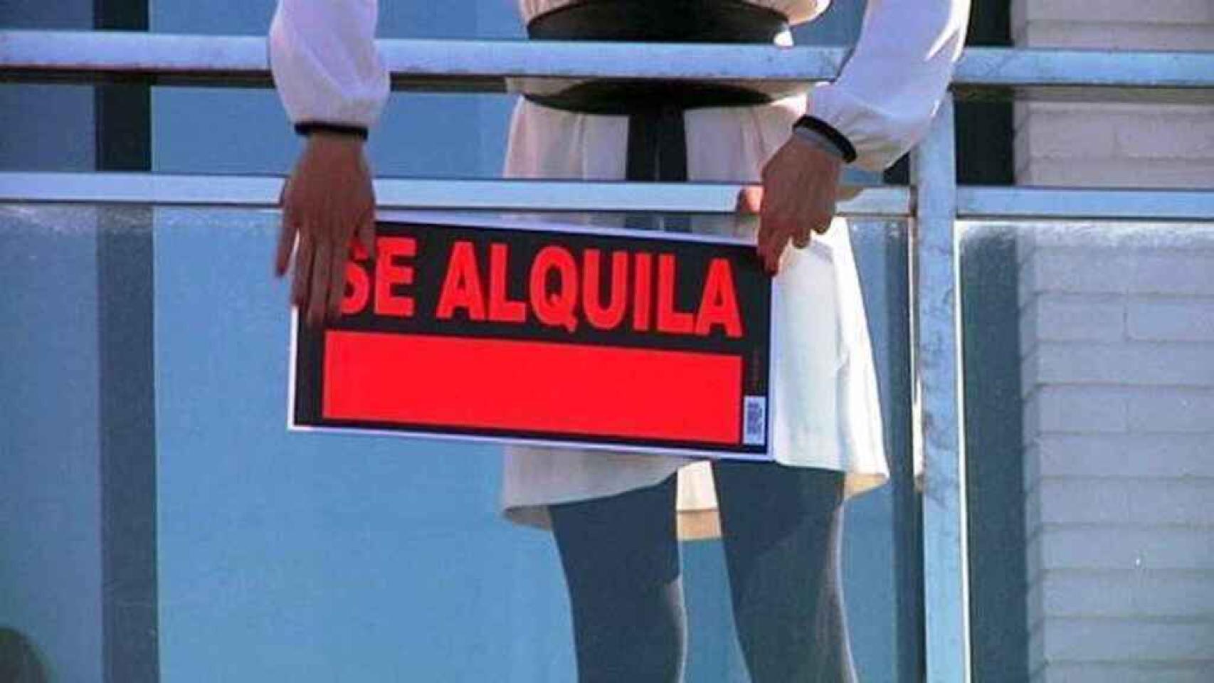 Un propietario coloca un cartel de alquiler.