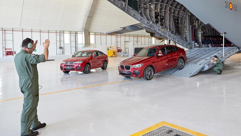 Los militares ayudan en la presentación del coche dentro del avión.