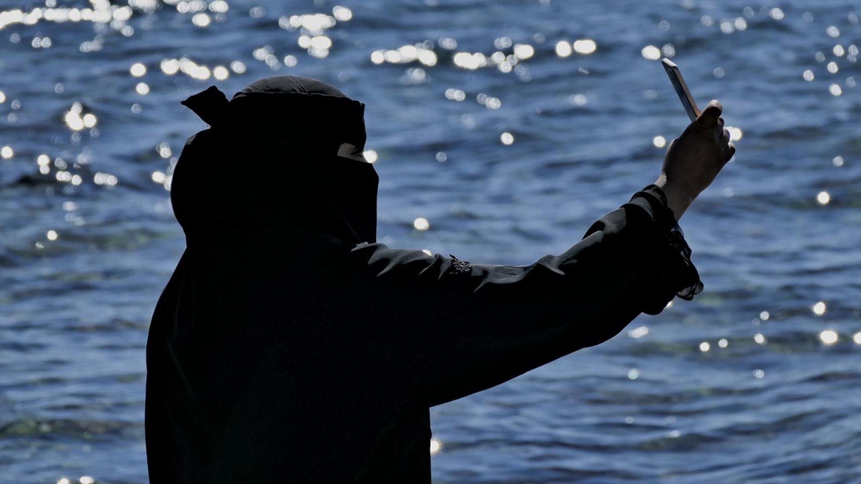 Una joven con hiyab se saca un selfie.