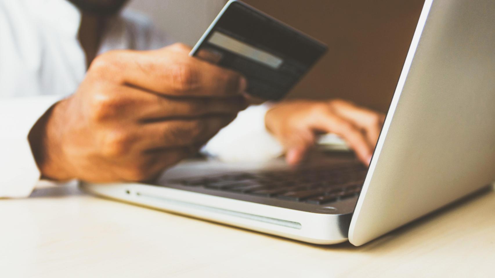 Un usuario comprobando los datos de su tarjeta física al hacer una compra online.