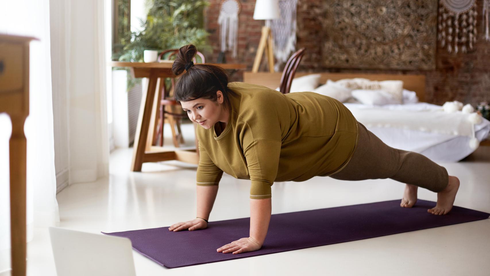 Una mujer realiza una plancha como ejercicio de core.