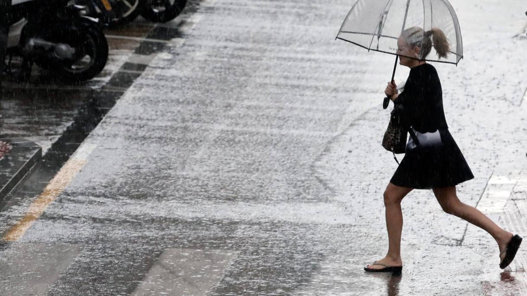 Uan mujer sostiene un paraguas mientras llueve.