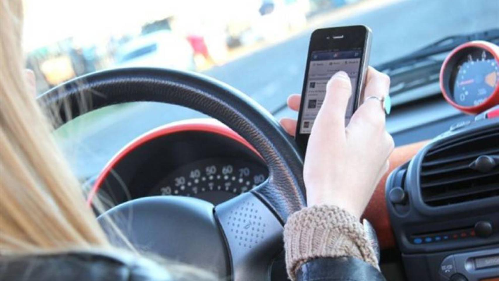 Una conductora usando el teléfono móvil