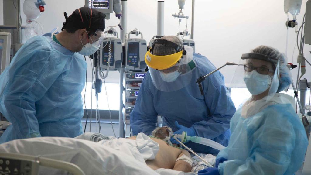 Un grupo de médicos junto a un paciente en la UCI .