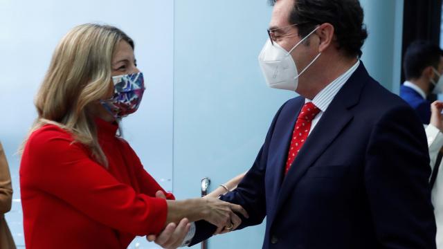 Yolanda Díaz, saluda con las dos manos al presidente de la CEOE, Antonio Garamendi.
