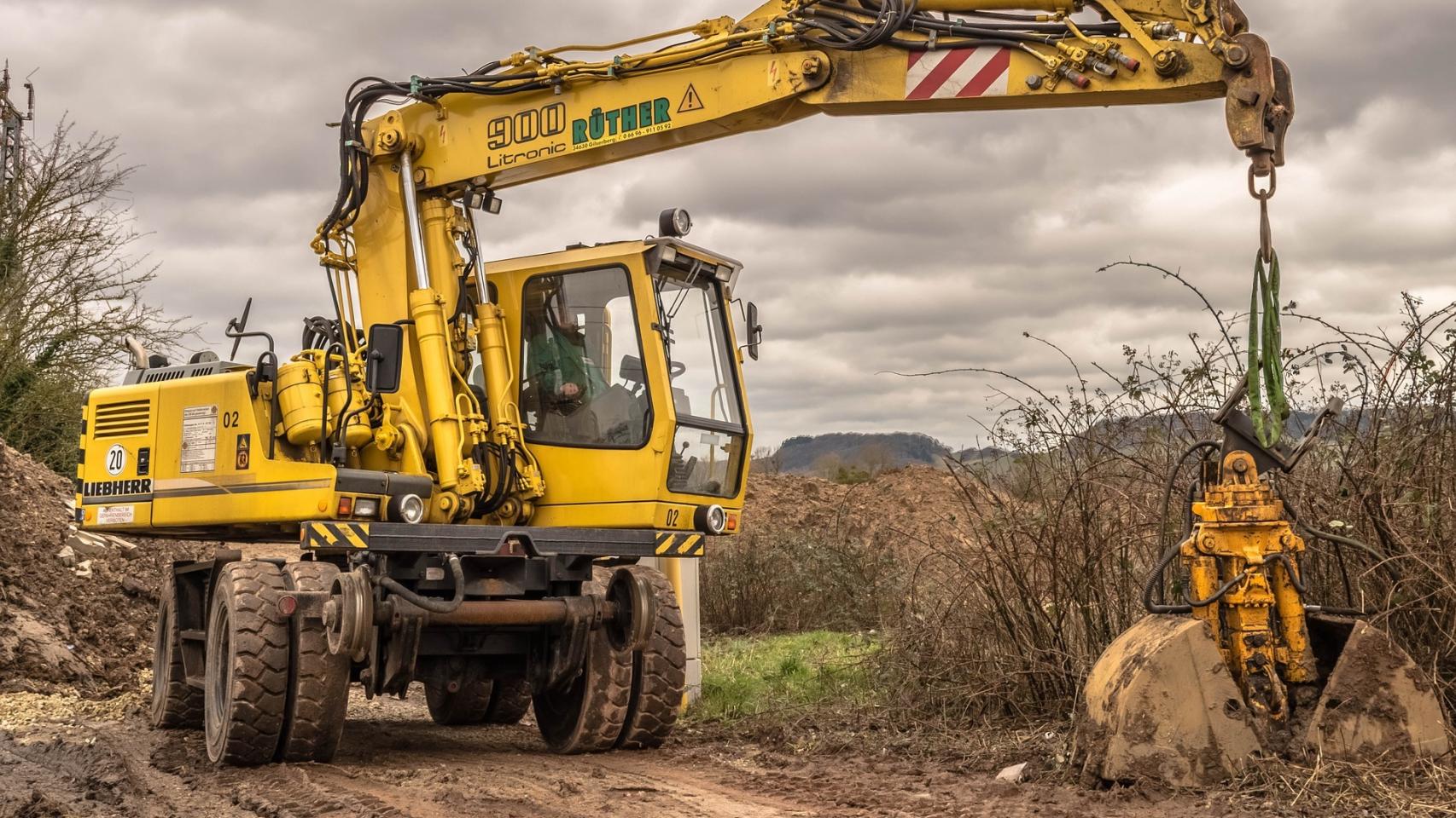 Un trabajador utiliza una excavadora en el sector agrario.