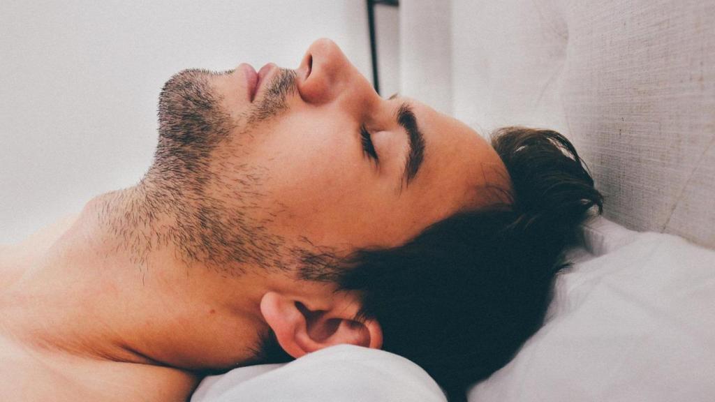 Un hombre duerme boca arriba.