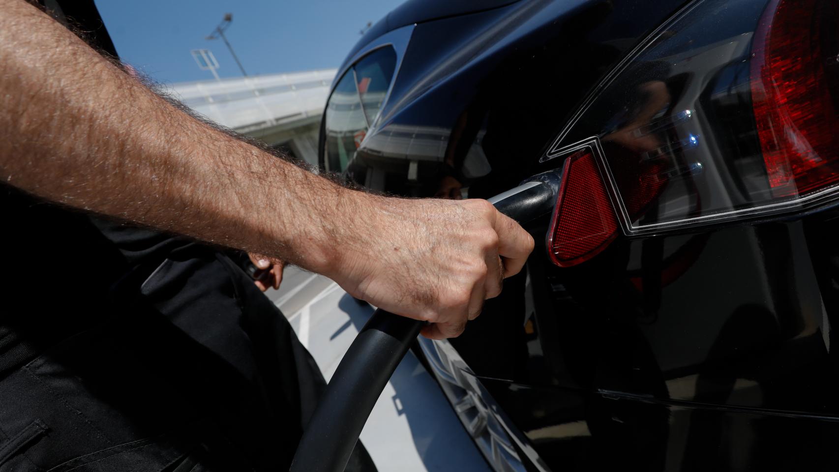 Un usuario cargando un coche eléctrico.