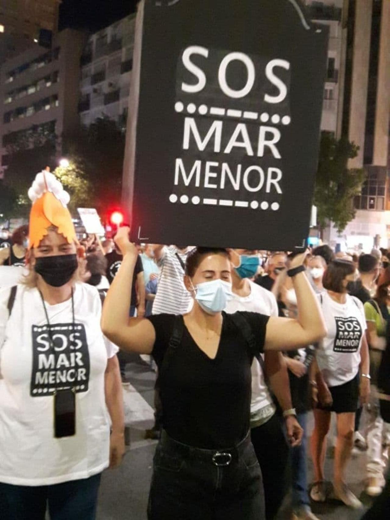 Una joven manifestándose con una lápida por el Mar Menor.