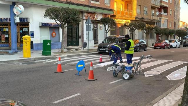 Unos operarios pintan un paso de cebra