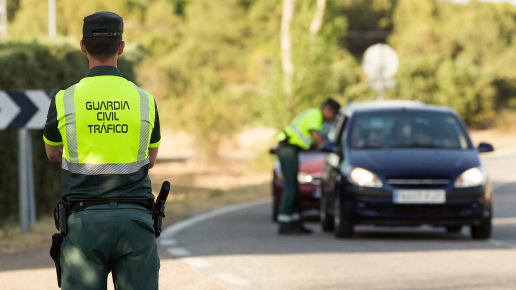 Dos agentes de la Guardia Civil sancionando a un conductor.