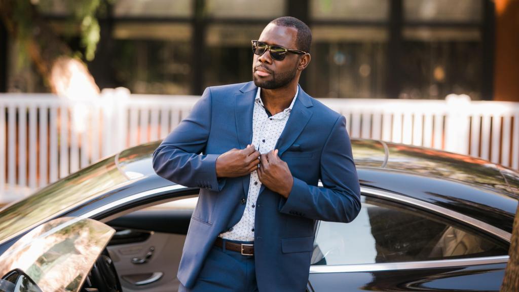 Un millonario bajando de su coche deportivo.