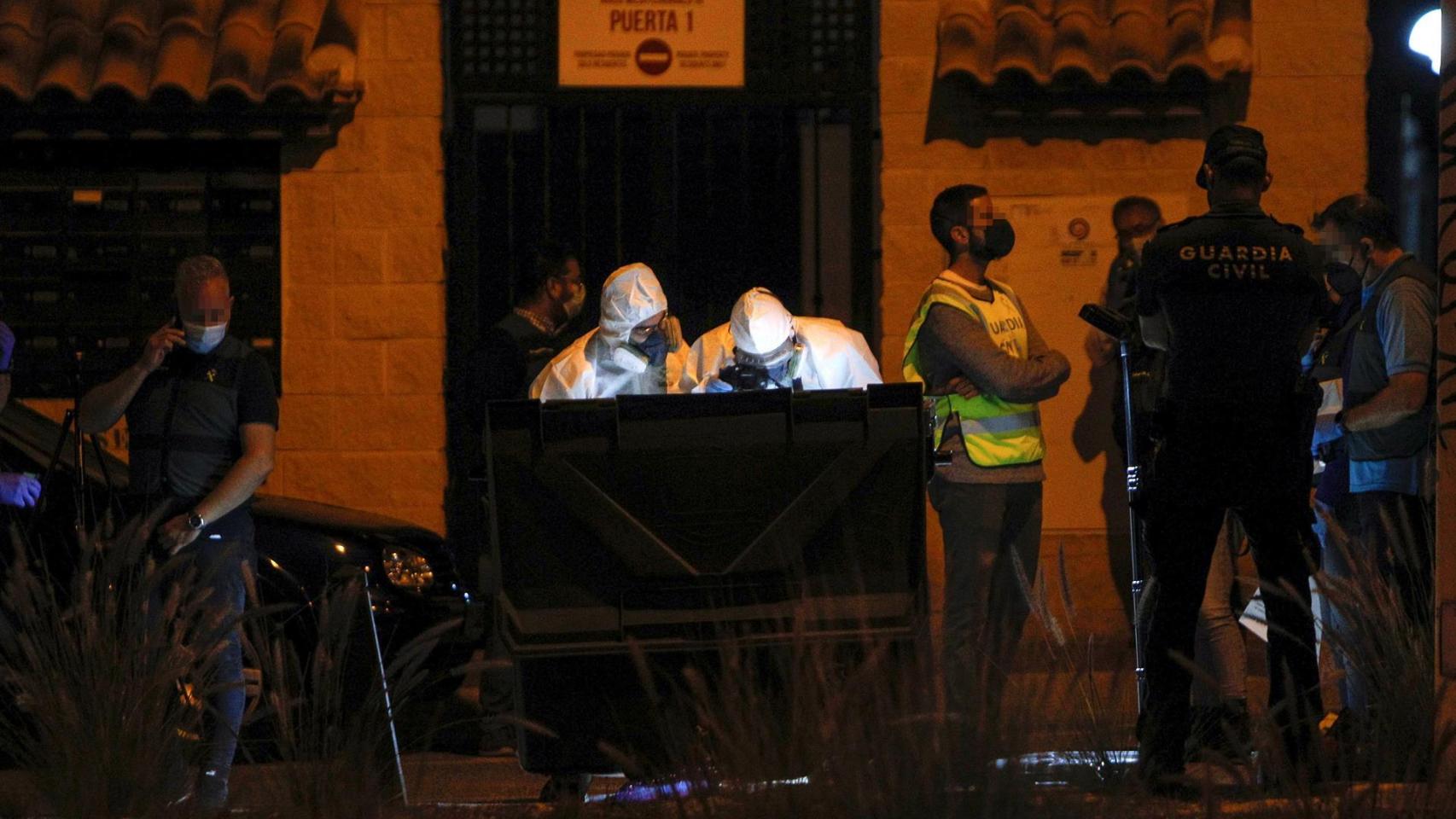 Los investigadores examinando los restos en la basura.