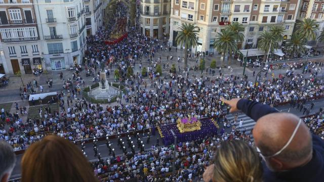 Personas viendo la Semana Santa desde un balcón.