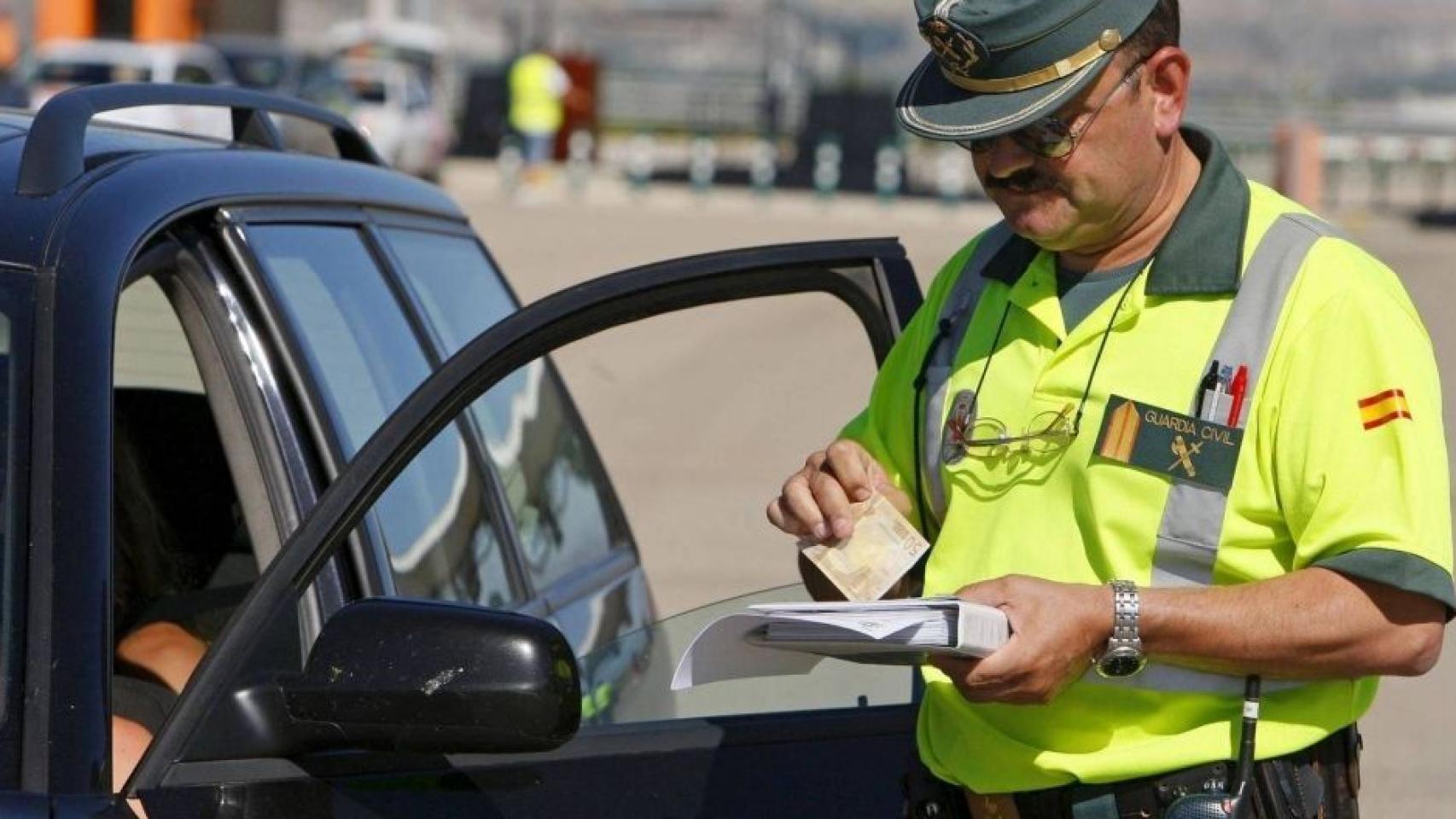 Un guardia civil multa a un conductor.