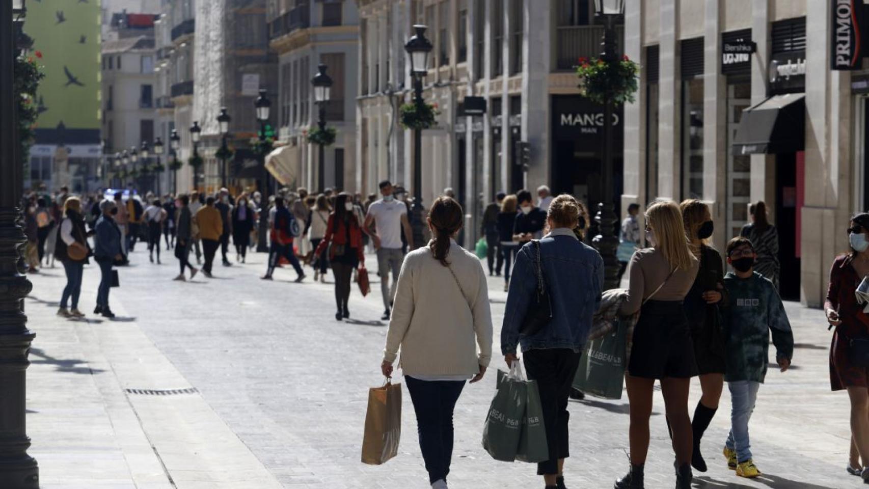 Una imagen de archivo de unos viandantes caminando por calle Larios tras hacer unas compras.