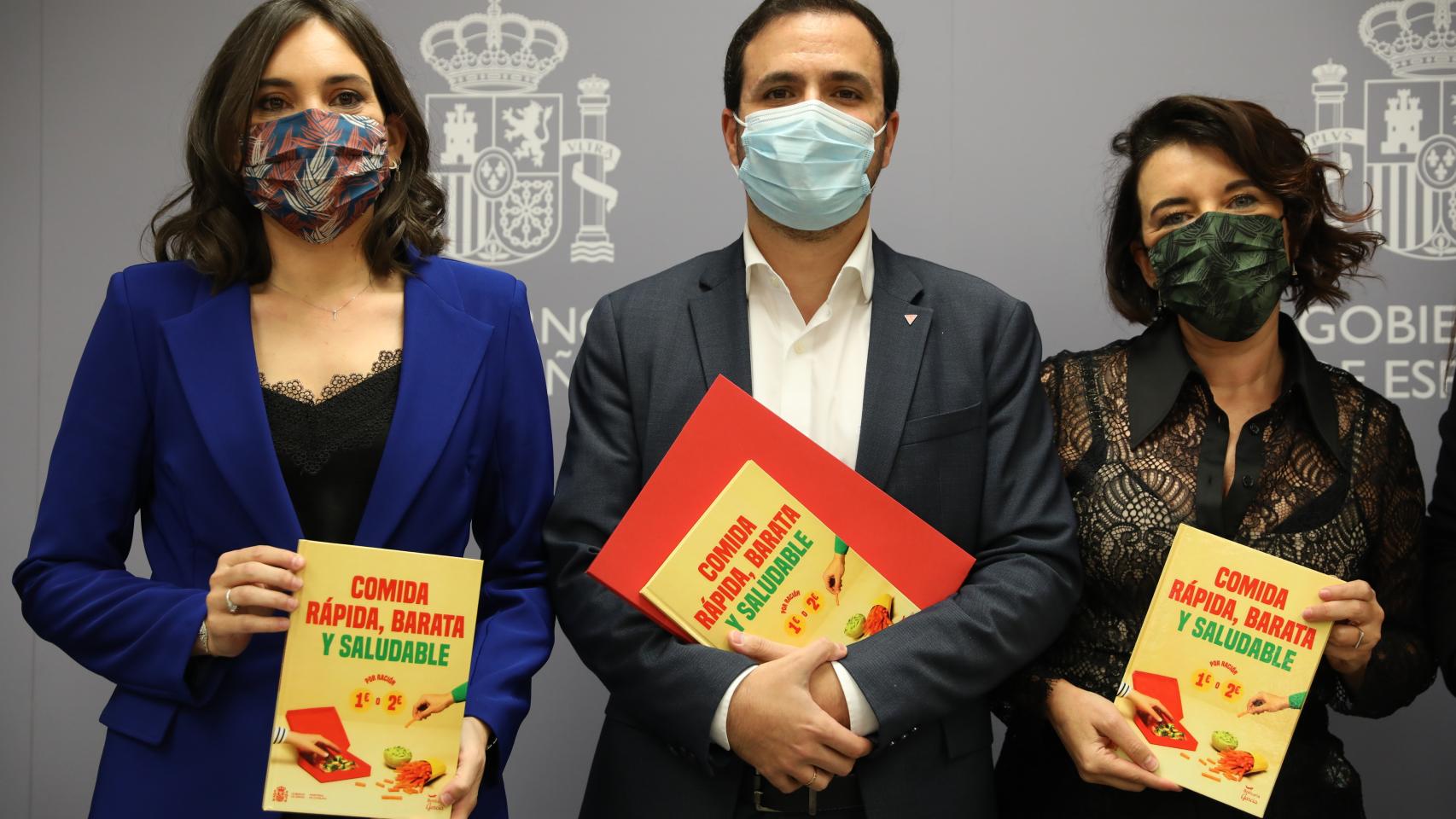 Alberto Garzón junto a las autoras del recetario 'Comida rápida, barata y saludable'. EP