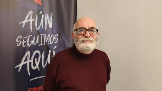 Guillermo Heras, ante el cartel de la Muestra de Teatro con el lema 'Aún seguimos aquí'.