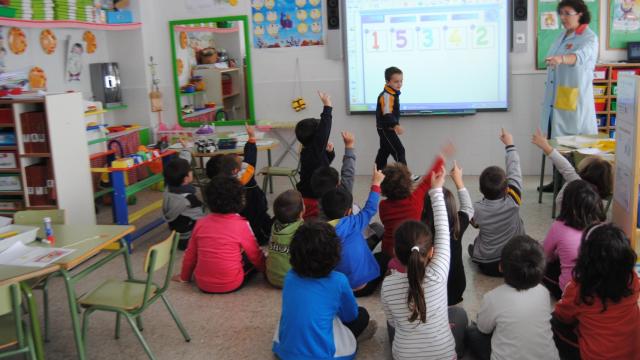 Un aula con una pizarra digital.