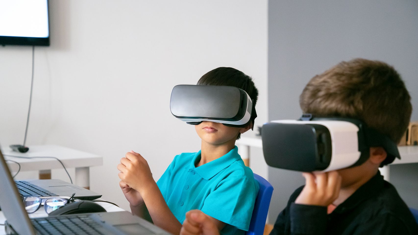 Dos niños con cascos de realidad virtual.