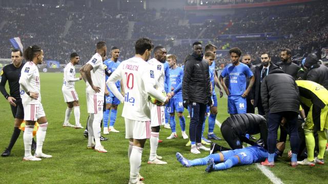 Dimitri Payet atendido por los médicos tras recibir un botellazo en el Lyon - Marsella
