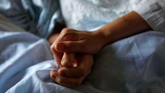 Manos unidas de dos familiares en un hospital