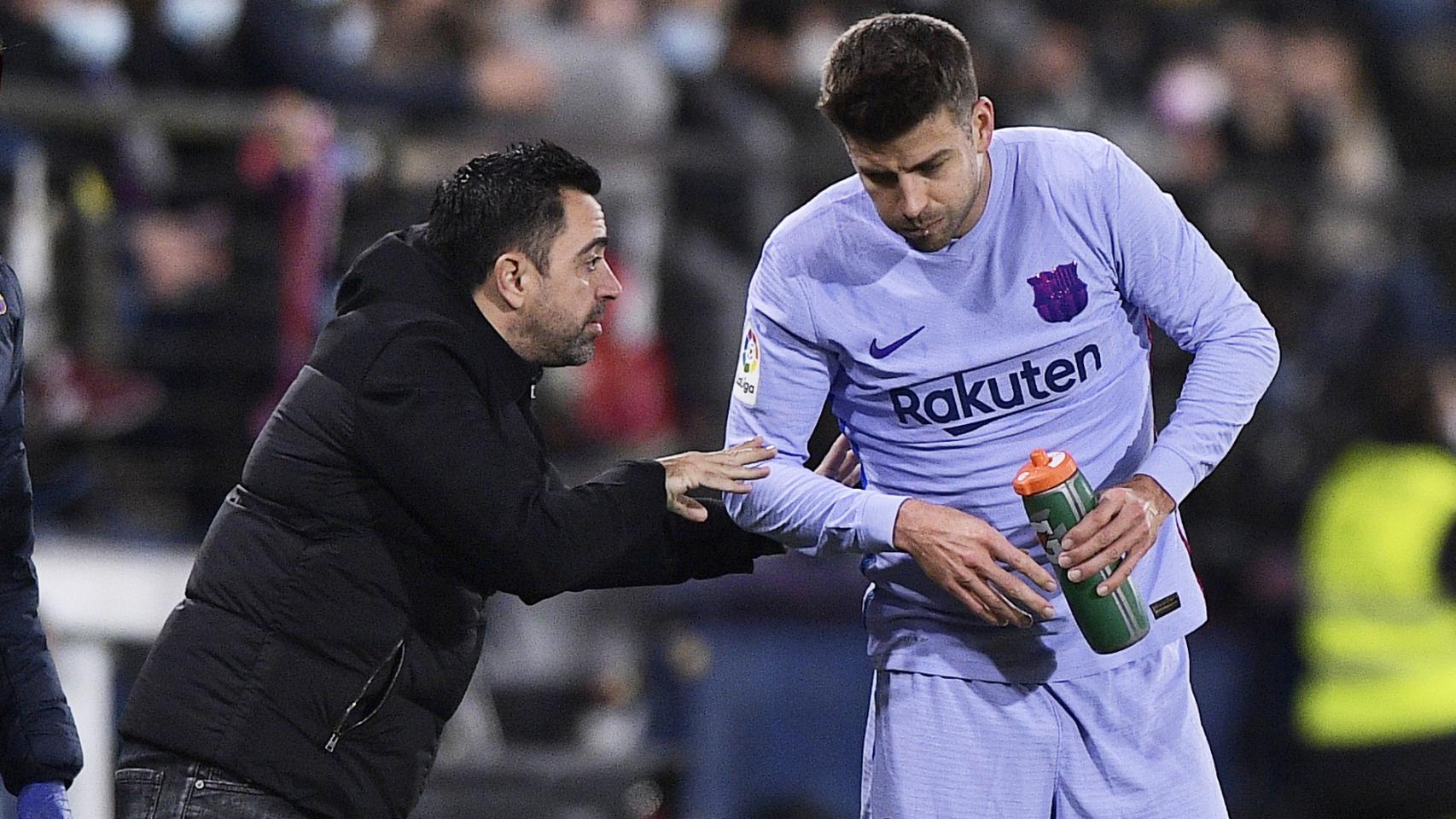 Piqué recibiendo indicaciones de Xavi Hernández