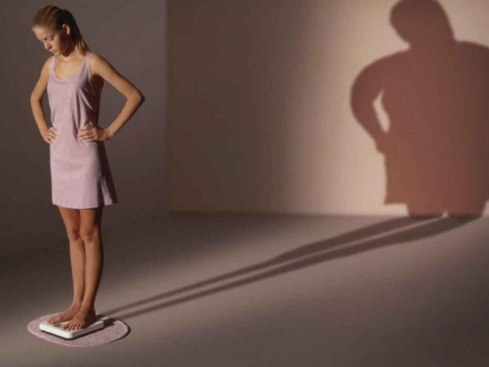 Una mujer se pesa en la báscula