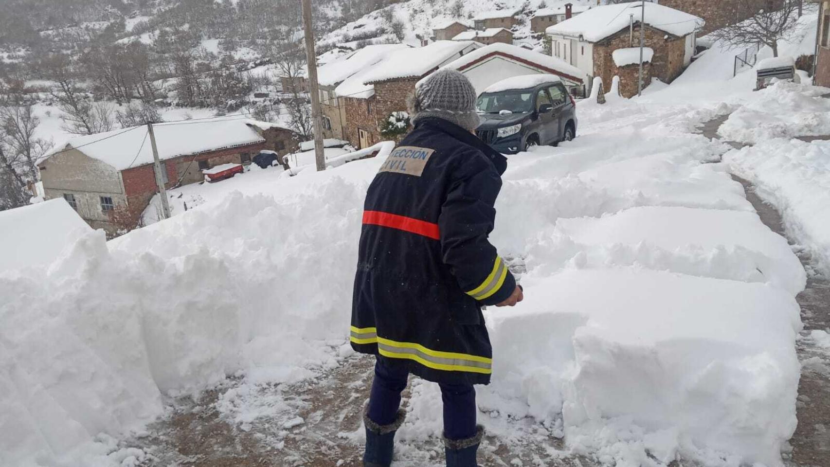 Un voluntario de Protección Civil retira la nieve para facilitar los accesos
