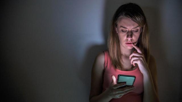 Una joven mira preocupada las redes sociales.