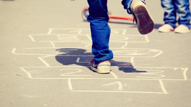 Un niño juega en el patio de un colegio.