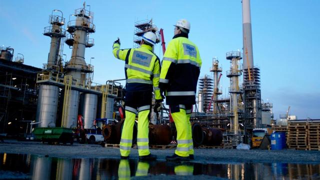 Unos operarios, frente a una industria.