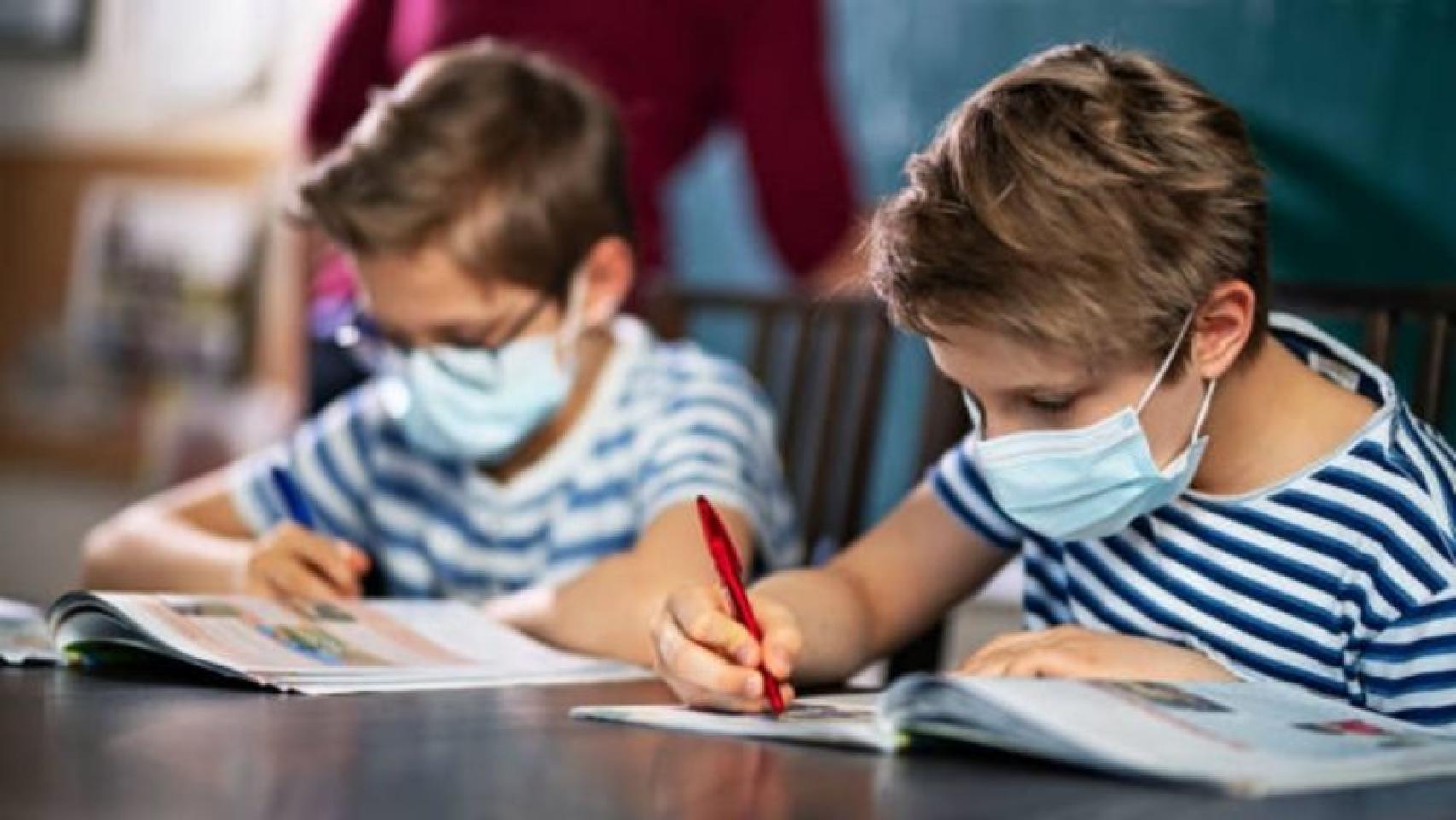 Dos niños con mascarilla en una clase, en imagen de archivo.