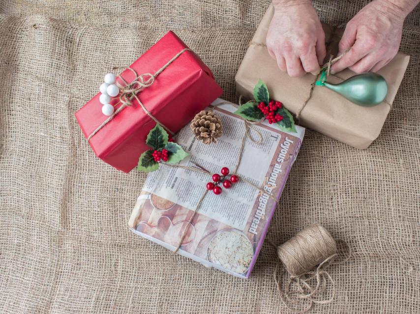 Imagen de archivo de una persona empaquetando regalos.