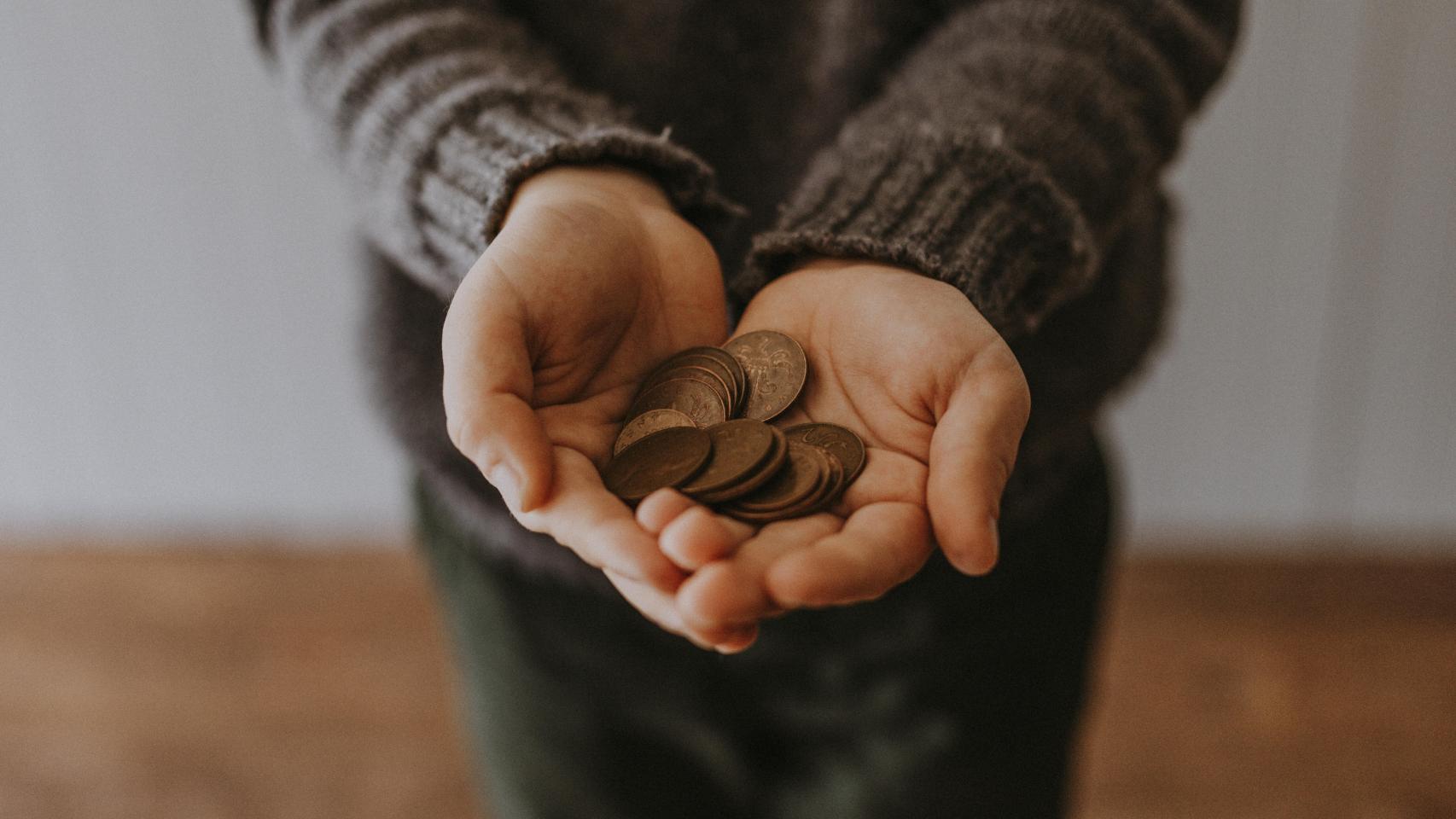 Un hombre sostiene unas monedas.