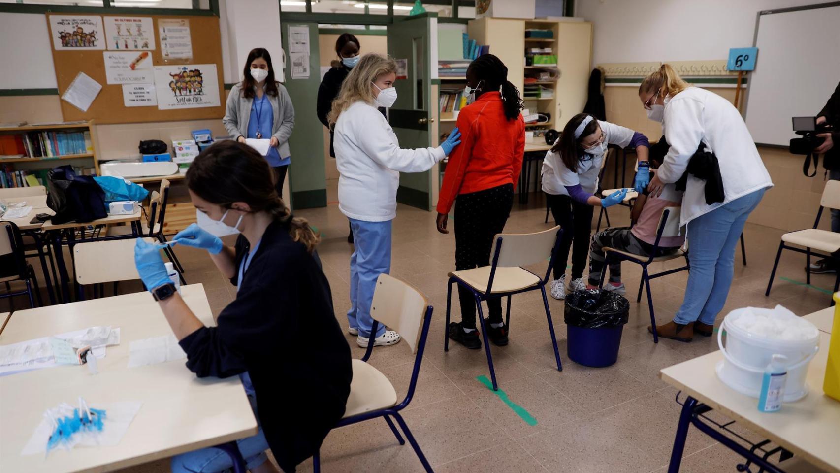Personal sanitario vacuna a dos menores de 12 años en un colegio valenciano.