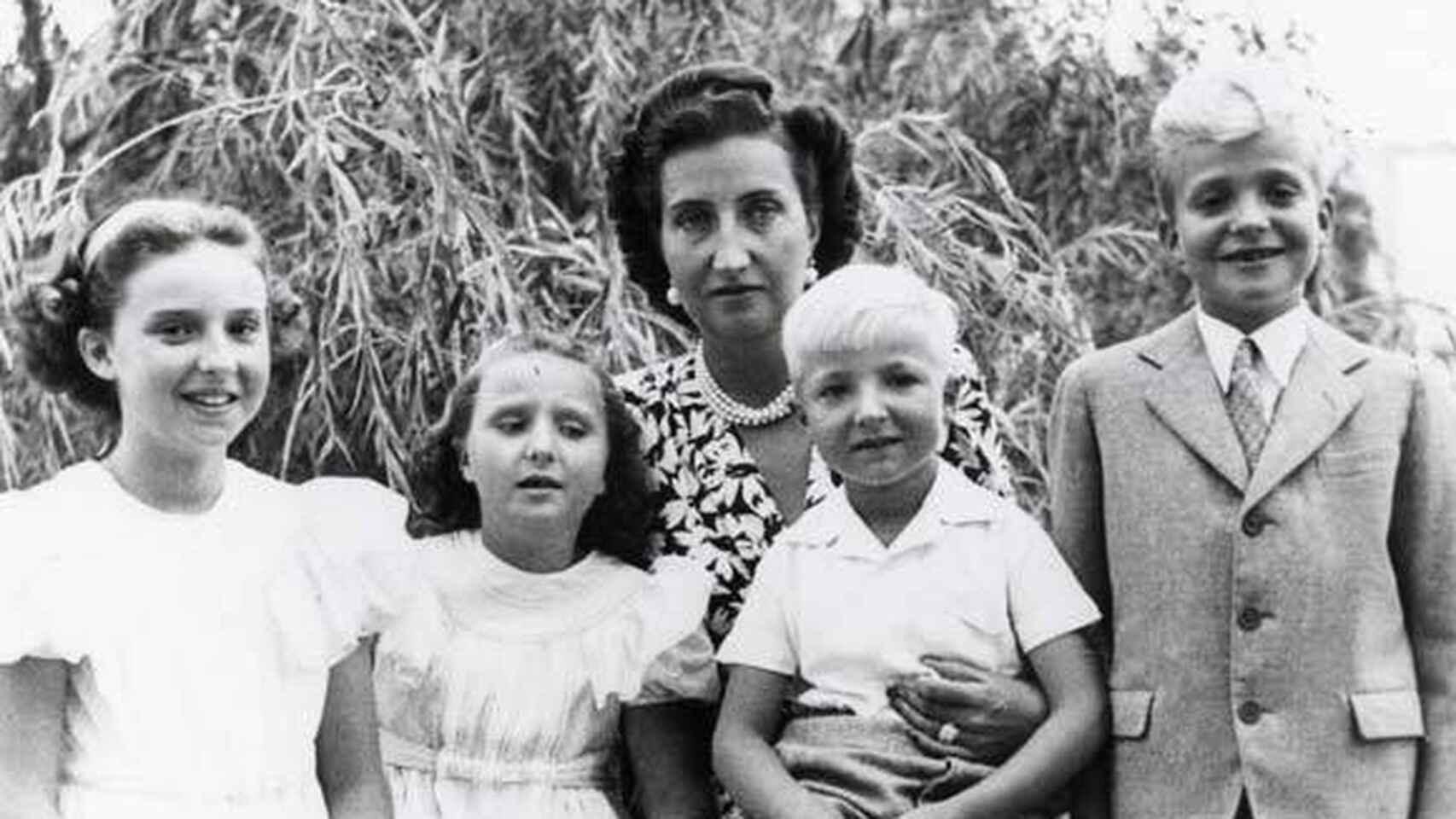 Las infantas Pilar y Margarita de Borbón junto a María de las Mercedes, que tiene en su regazo al pequeño Alfonso. A la derecha, Juan Carlos de Borbón.