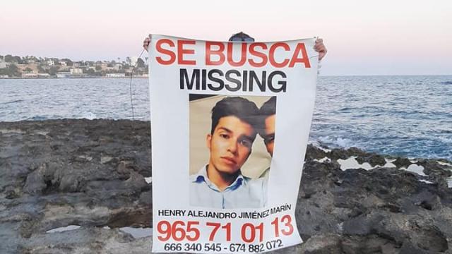 Una persona sostiene un cartel del desaparecido Henry.
