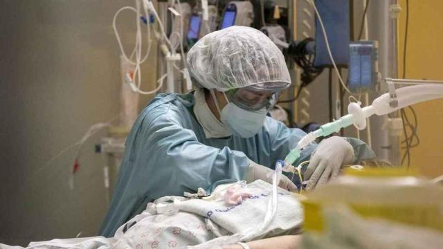 Una médica atiende a un paciente en cuidados intensivos.