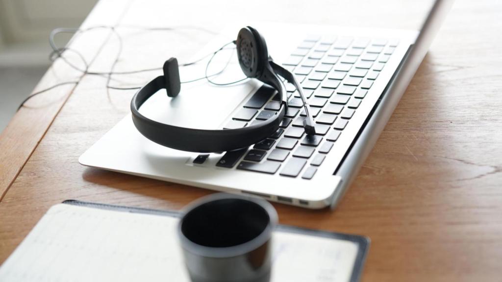 Unos cascos de un trabajador de servicios de atención al cliente sobre un teclado de ordenador.