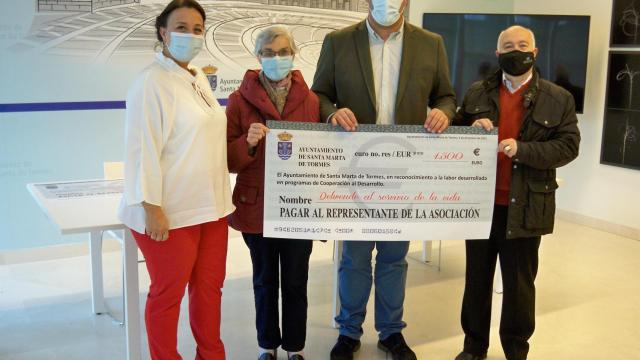 El alcalde David Mingo entrega el cheque de la ayuda a los responsables de la ONG