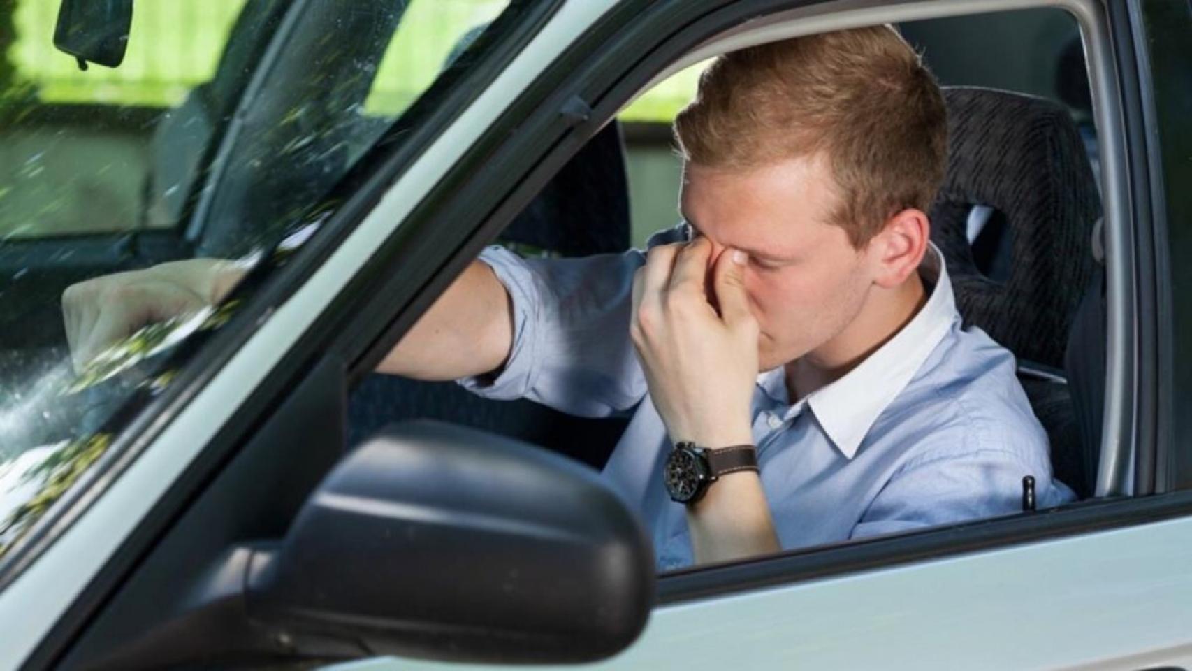 Un hombre se frota los ojos conduciendo